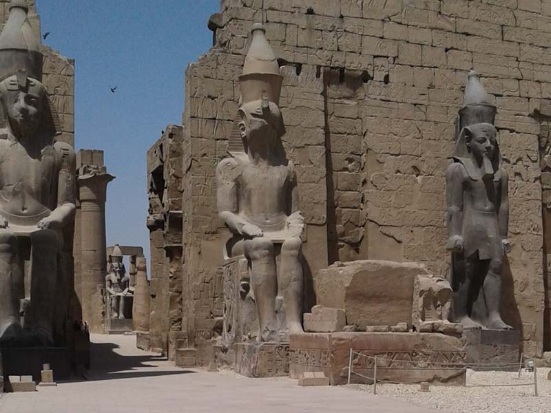 large statues outside the ruins of an ancient structure