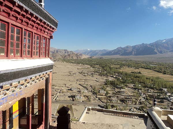 view from red building with mountains trees and small buildings in the background