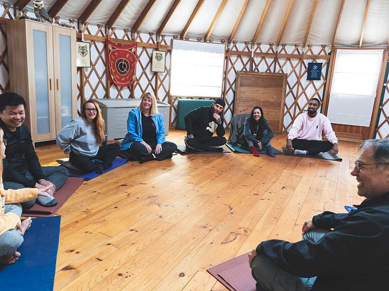 room of men and women sitting on mats